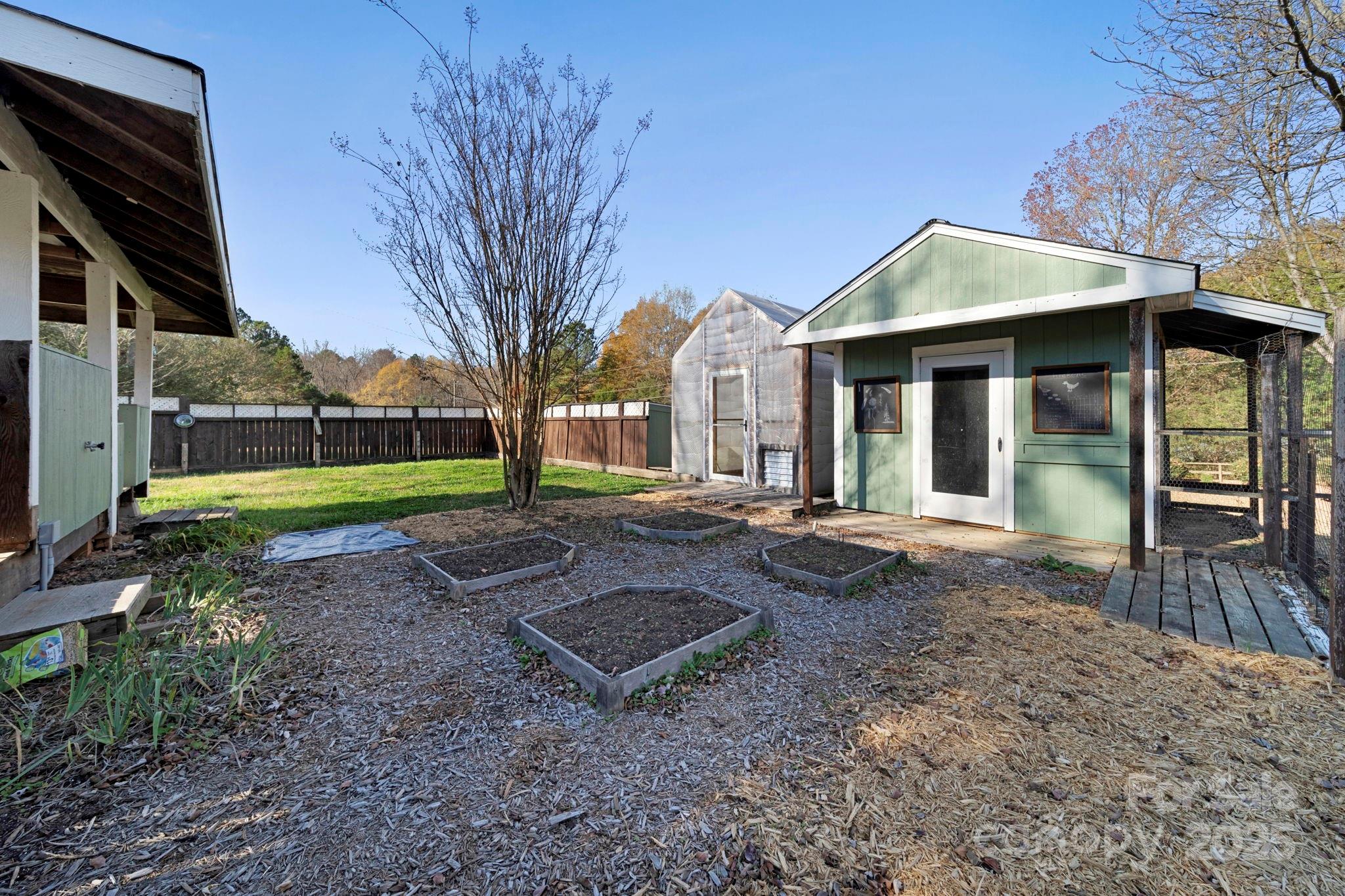 3400 Griffith Road Monroe, NC 28112 - Photo 9 of 46 a view of a house with a yard and lawn chairs under a large tree