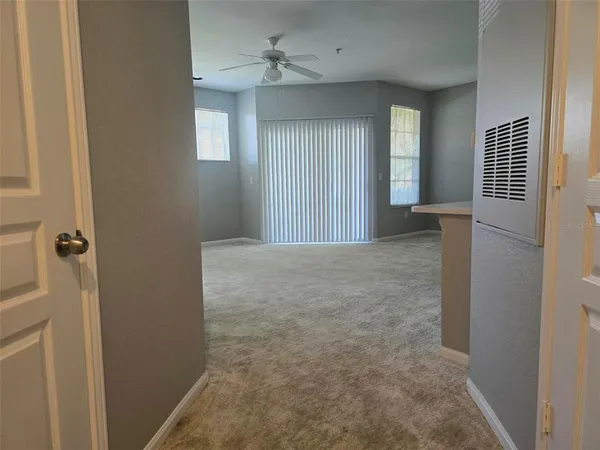 a view of a hallway with windows and chandelier