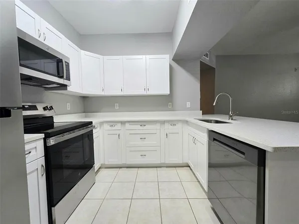a kitchen with a sink stove and microwave