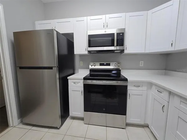 a kitchen with stainless steel appliances a refrigerator stove and microwave