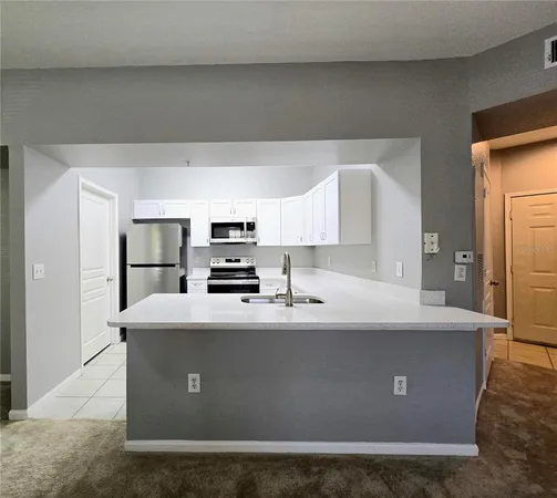 a view of a kitchen with stainless steel appliances granite countertop a refrigerator a sink dishwasher a stove with wooden floor