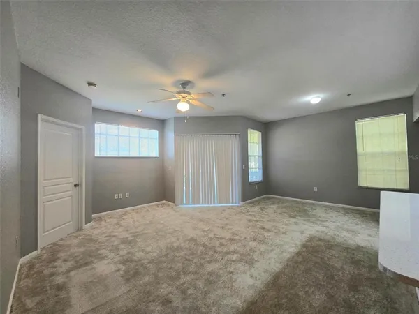 a view of an empty room with window and cabinet
