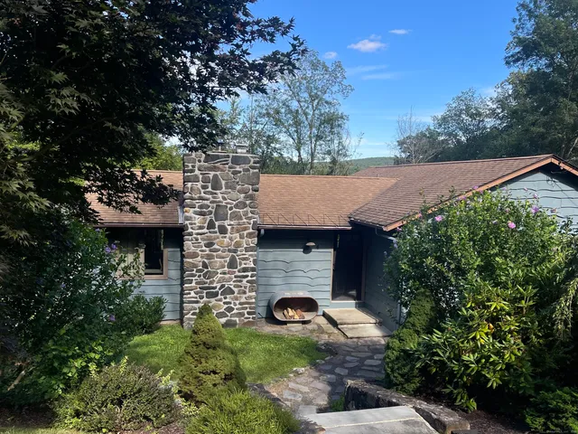 a front view of a house with yard and green space