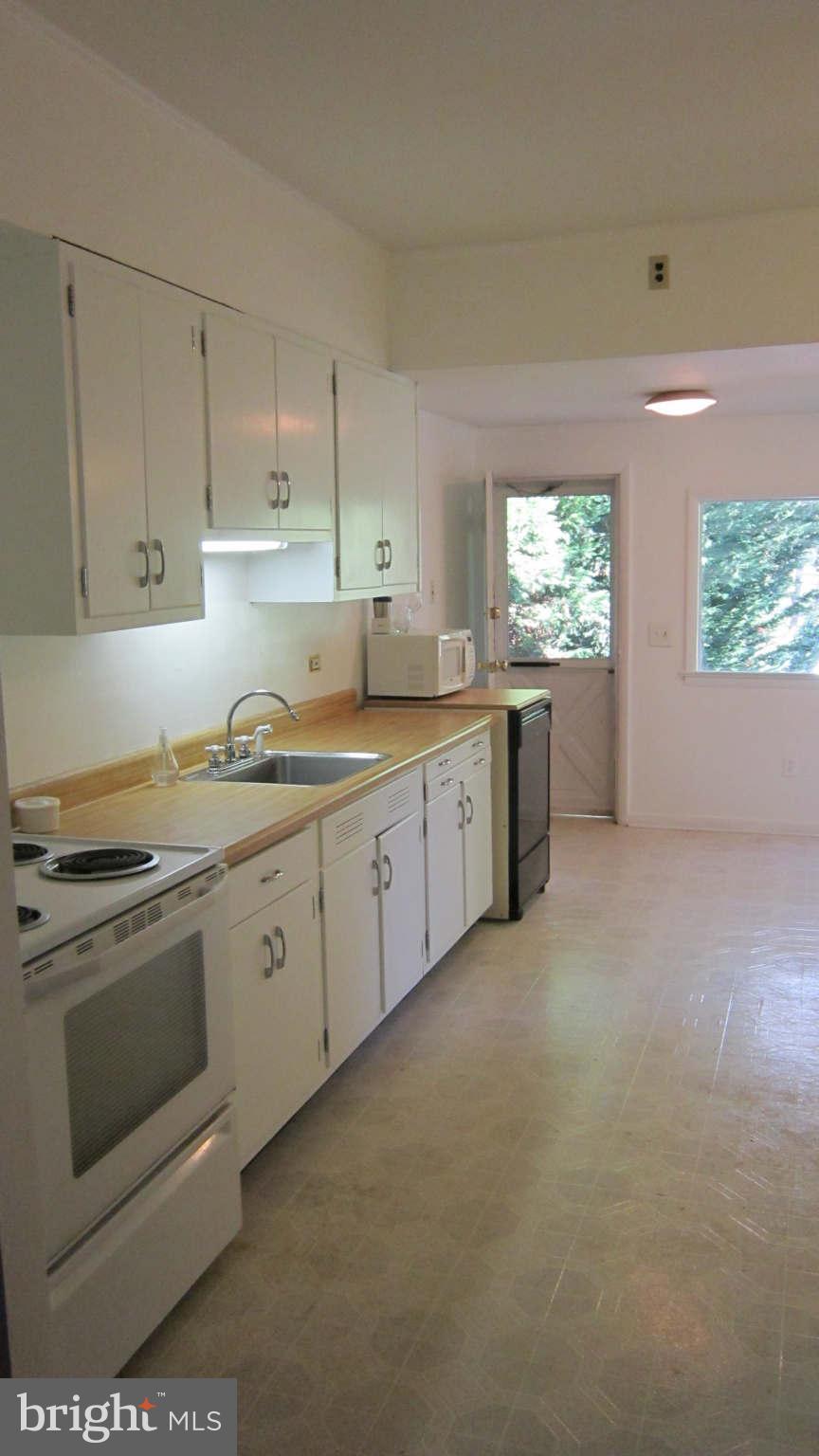4525 Wilmslow Road Baltimore, MD 21210 - Photo 5 of 14 a kitchen with granite countertop white cabinets and white appliances