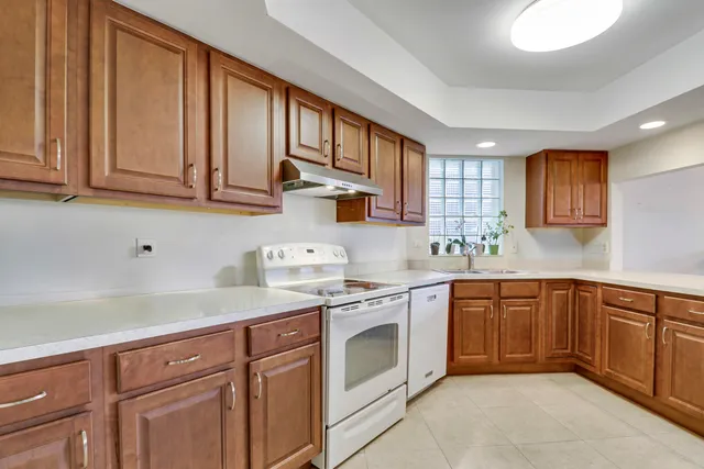 a kitchen with cabinets appliances a sink and a window