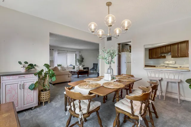 a view of a dining room with furniture and a chandelier