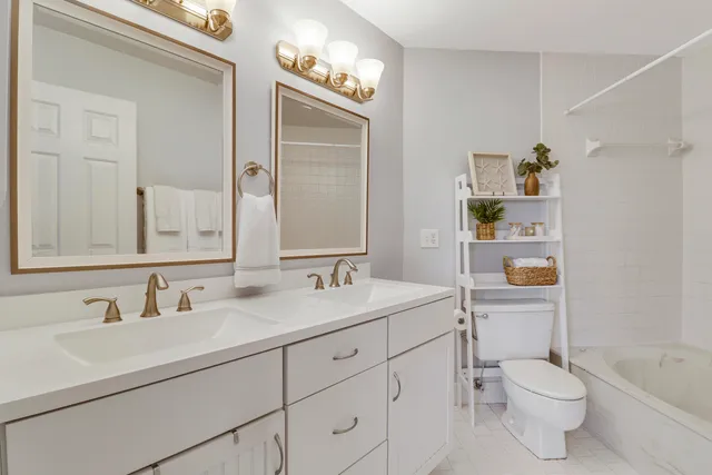 a bathroom with a granite countertop toilet sink and mirror