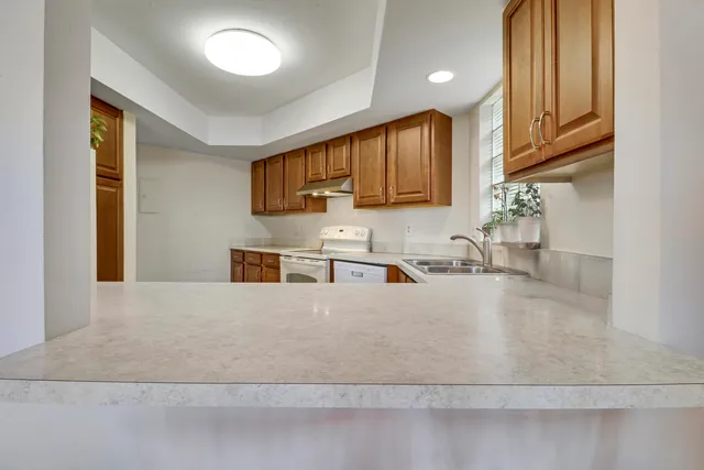 a kitchen with stainless steel appliances granite countertop a sink refrigerator and cabinets