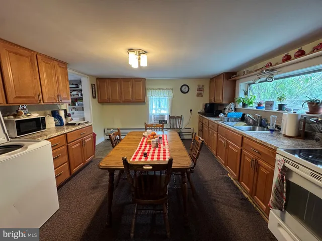 a kitchen with a table chairs stove and microwave