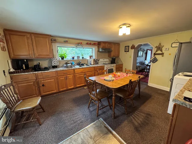 a kitchen with a dining table chairs and a refrigerator