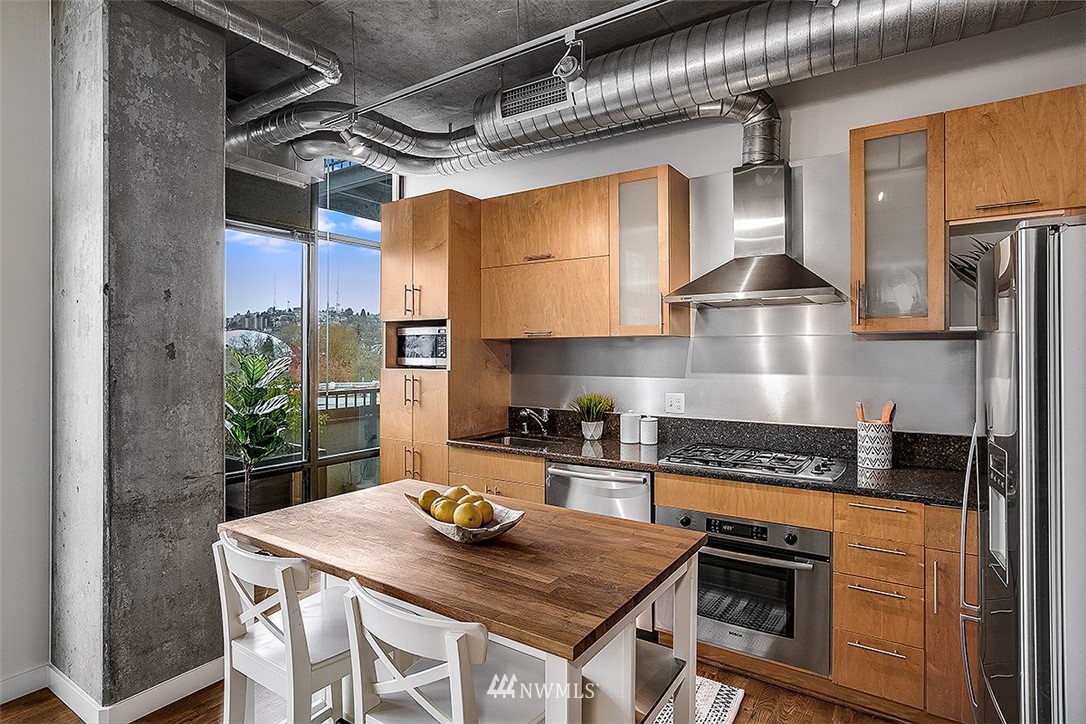 2720 3rd Avenue, Unit 502 Seattle, WA 98121 - Photo 11 of 28 a kitchen with stainless steel appliances granite countertop a stove a sink and a refrigerator