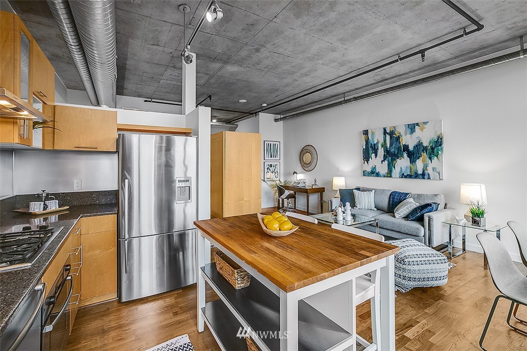 2720 3rd Avenue, Unit 502 Seattle, WA 98121 - Photo 9 of 28 a kitchen with a stove a refrigerator and a dining table