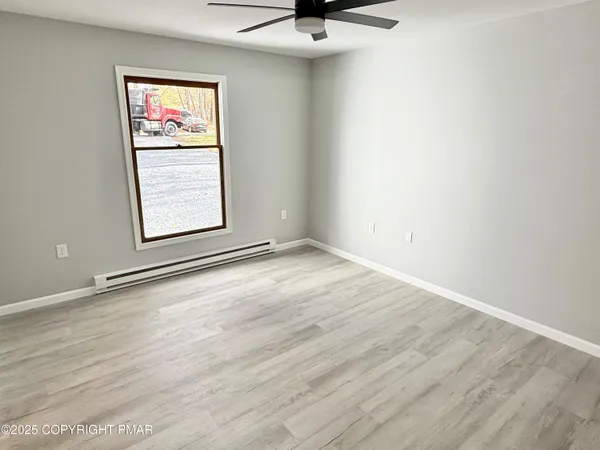 an empty room with a window and wooden floor