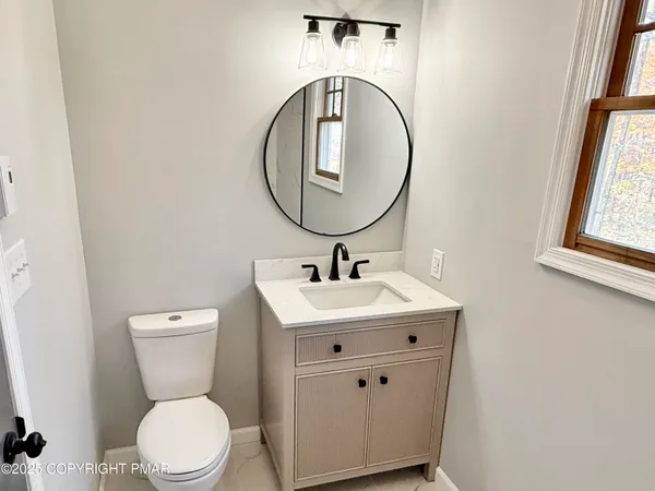 a bathroom with a toilet a sink and a mirror