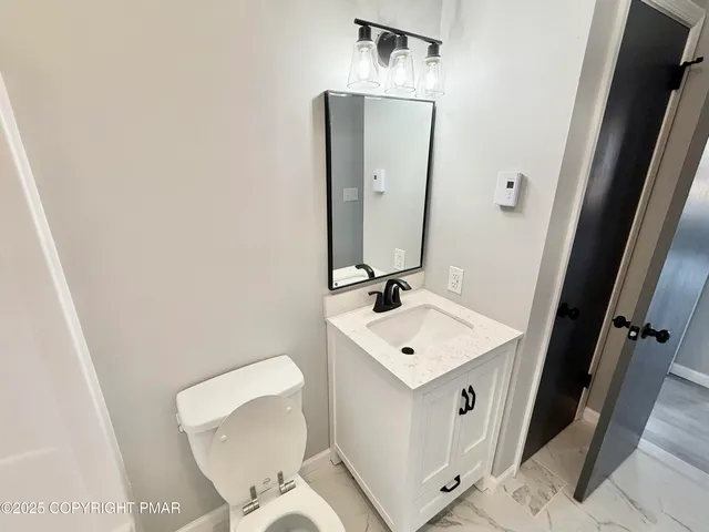 a bathroom with a toilet sink and mirror