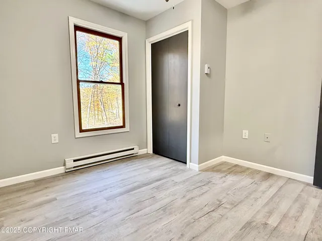 an empty room with windows and closet