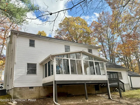 a white house with a large window and wooden fence
