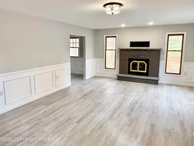 a view of a livingroom with wooden floor and a fireplace