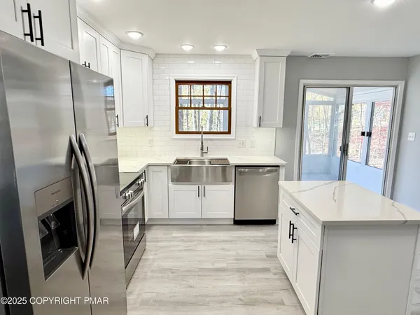 a kitchen with a sink a refrigerator a washer dryer and cabinets