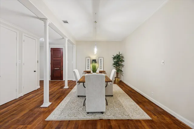 a dining room with furniture potted plants and wooden floor