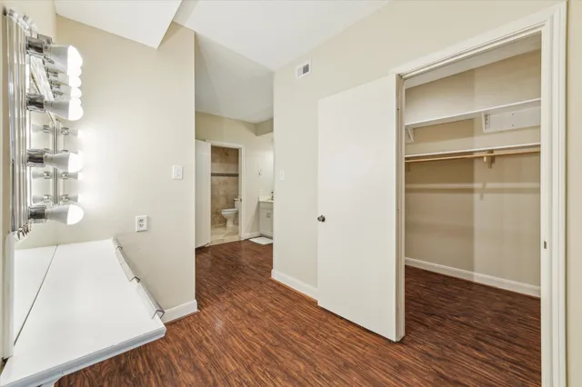 an empty room with wooden floor and ceiling fan