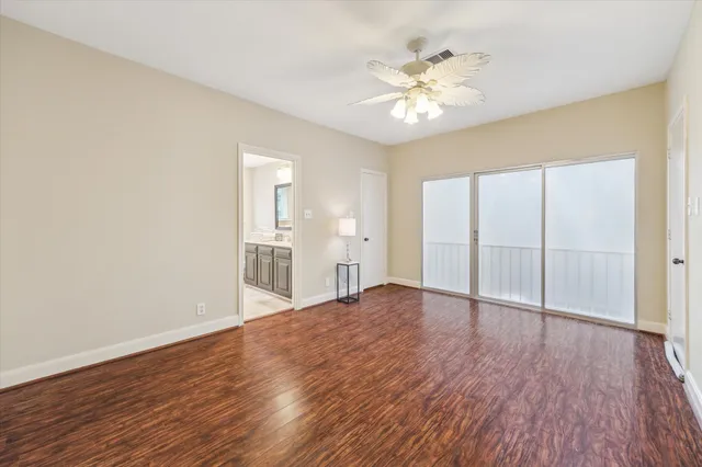 a view of empty room with wooden floor and fireplace
