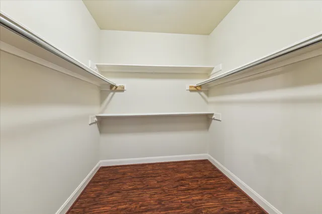 a view of empty room with wooden floor and fireplace