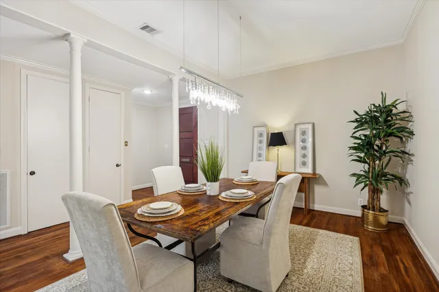 a view of a dining room with furniture a chandelier and wooden floor