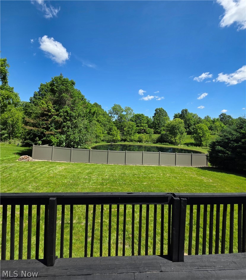 5860 Kirk Road Canfield, OH 44406 - Photo 8 of 12 Expansive outdoor area featuring a pond with a surrounding fence, green lawn, and mature trees