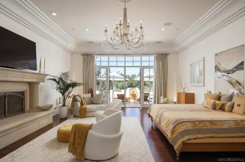 a bedroom with a bed a flat screen tv and a fireplace