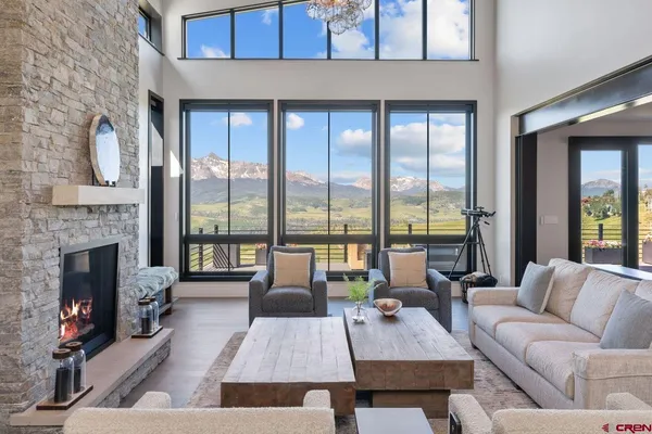 a living room with furniture large window and a fireplace