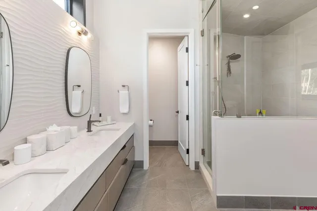 a spacious bathroom with a double vanity sink mirror and bathtub
