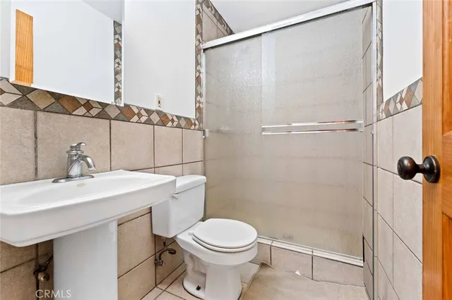 a bathroom with a sink a toilet and a shower