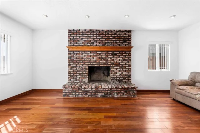 a living room with fireplace furniture and a wooden floor