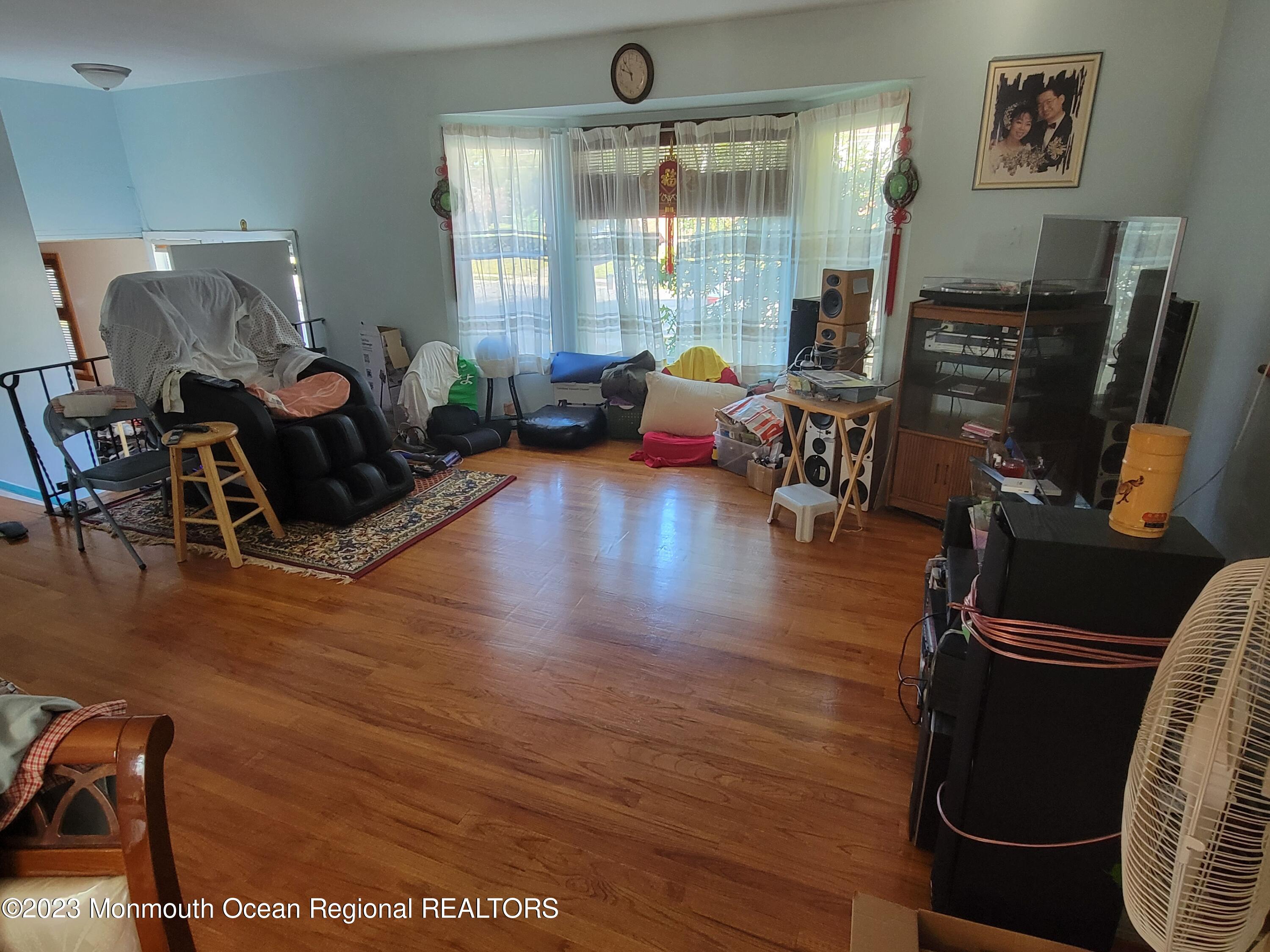96 Newbury Road Howell, NJ 07731 - Photo 3 of 12 a living room with furniture a flat screen tv and a large window