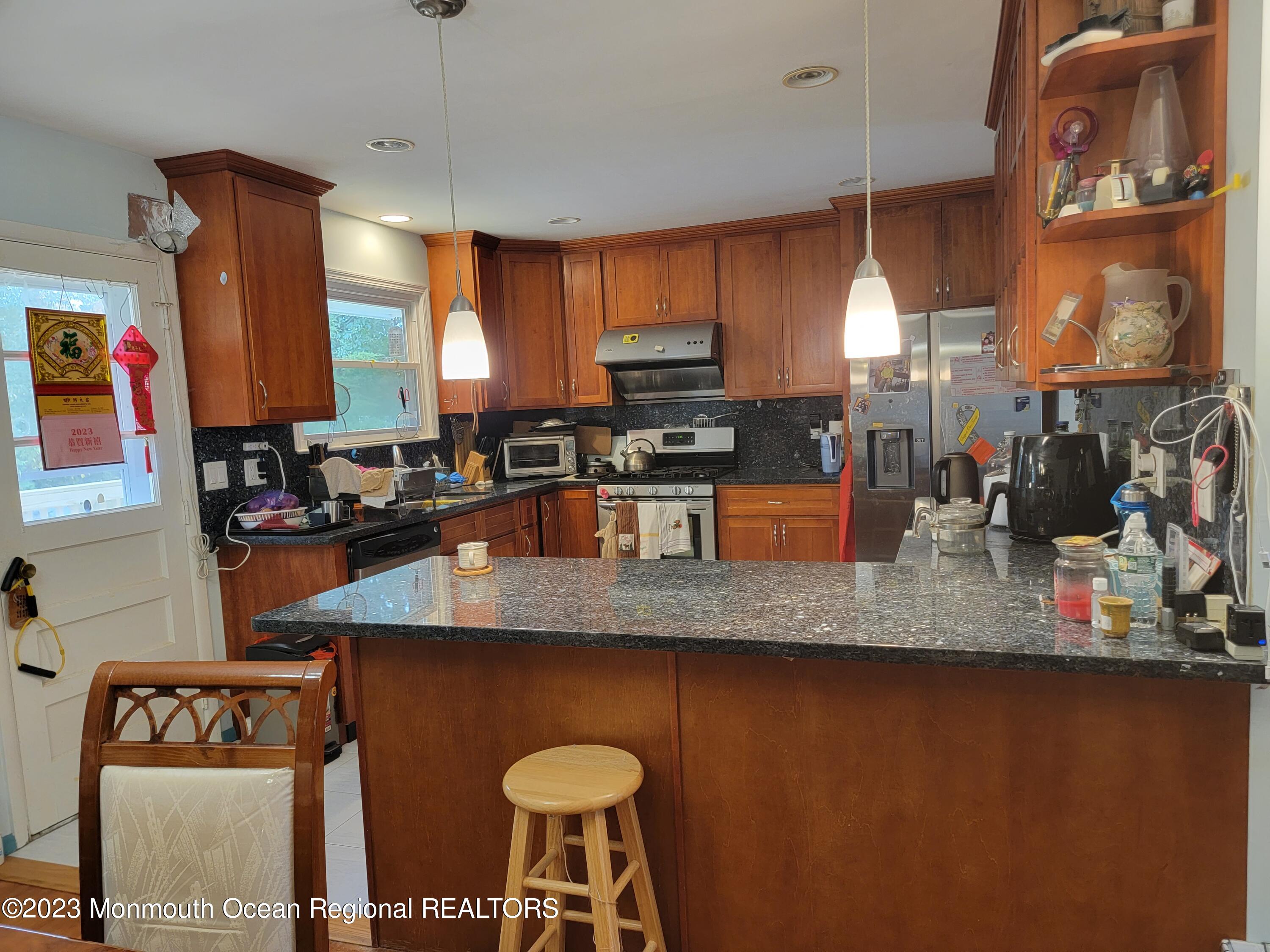 96 Newbury Road Howell, NJ 07731 - Photo 5 of 12 a kitchen with stainless steel appliances granite countertop a sink a stove and a wooden cabinets