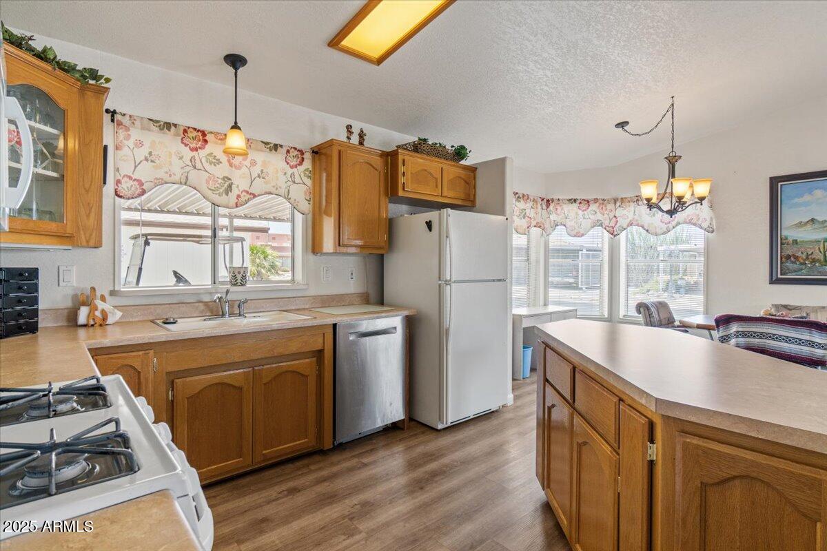 2054 North Thornton Road, Unit 125 Casa Grande, AZ 85122 - Photo 10 of 26 a kitchen with refrigerator a stove and a sink with wooden floor
