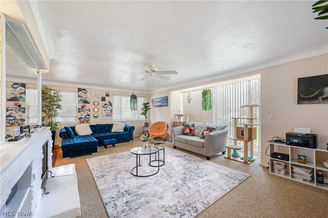 6597 York Road Parma Heights, OH 44130 - Photo 7 of 34 Carpeted living room with ceiling fan, a wealth of natural light, and a textured ceiling
