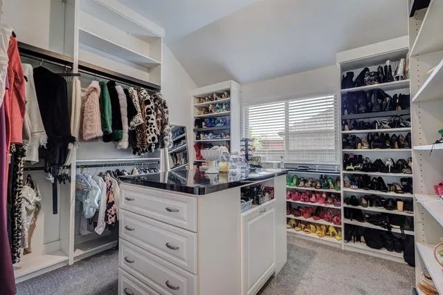 walk in closet with clothes and shoes