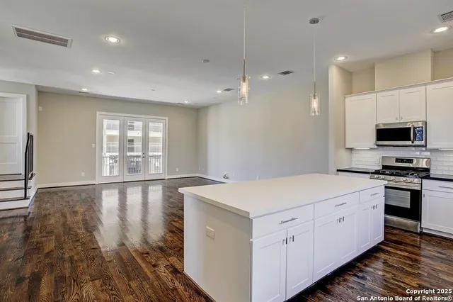 a large kitchen with a sink and large window