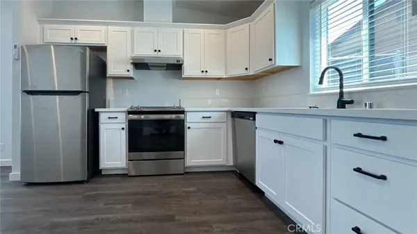 a kitchen with stainless steel appliances a refrigerator sink and cabinets