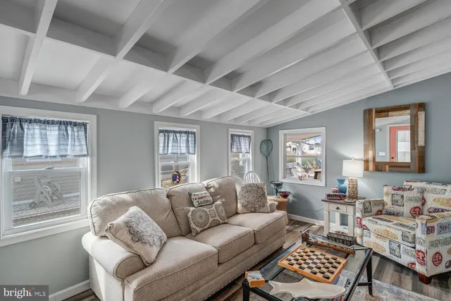 a living room with furniture a rug and wall paintings