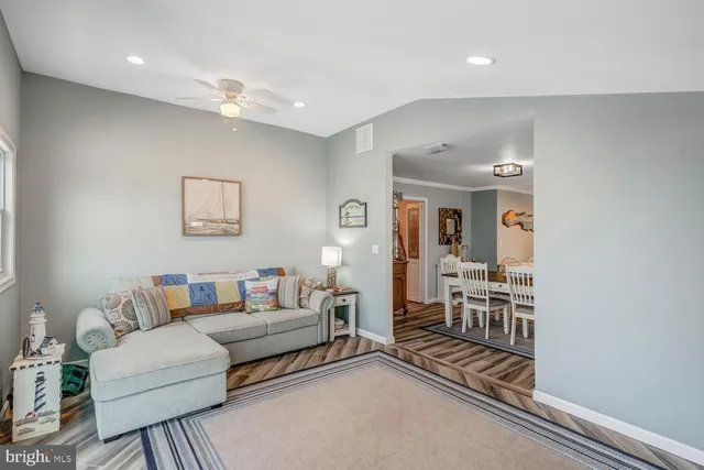 a room with furniture a flat screen tv and kitchen view