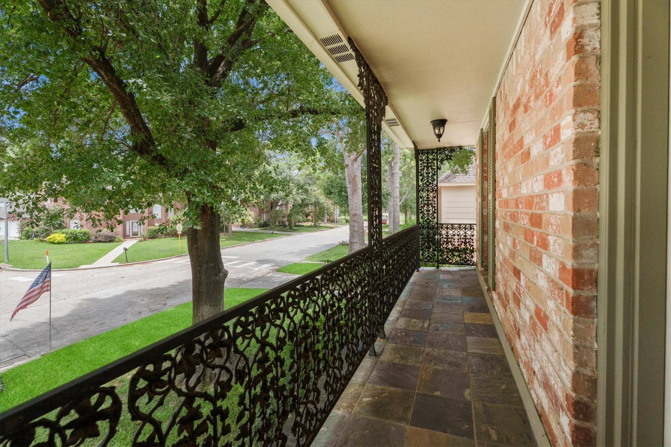 9103 Herts Road Spring, TX 77379 - Photo 35 of 46 The second-floor landing opens to a beautiful balcony with slate flooring and classic wrought iron railings. This beautiful view looks down the tree-lined street of this lovely neighborhood.