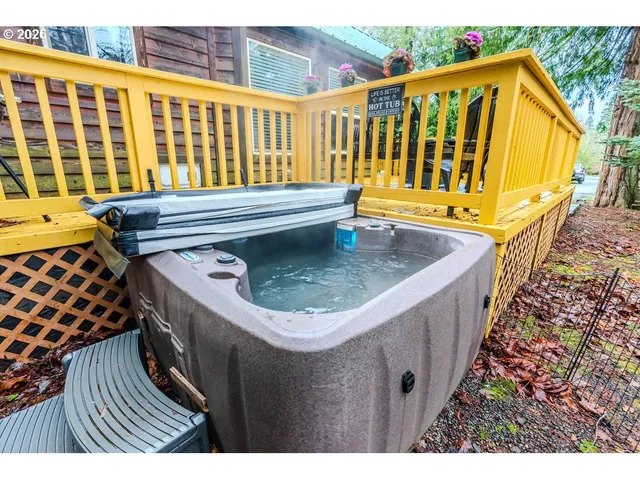 a view of a wooden house with a small yard and wooden fence