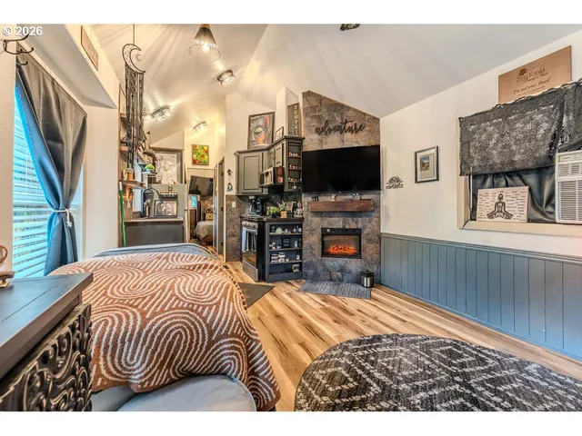 a bedroom with a bed a flat screen tv and a fireplace