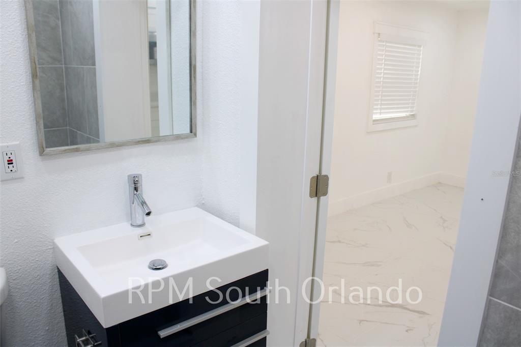 1245 North Pine Hills Road Orlando, FL 32808 - Photo 6 of 14 a bathroom with a sink and a mirror
