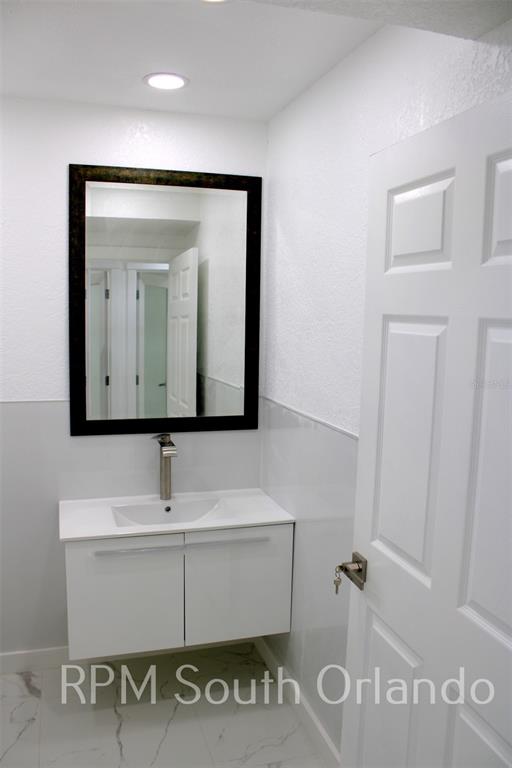 1245 North Pine Hills Road Orlando, FL 32808 - Photo 8 of 14 a bathroom with a sink and a mirror