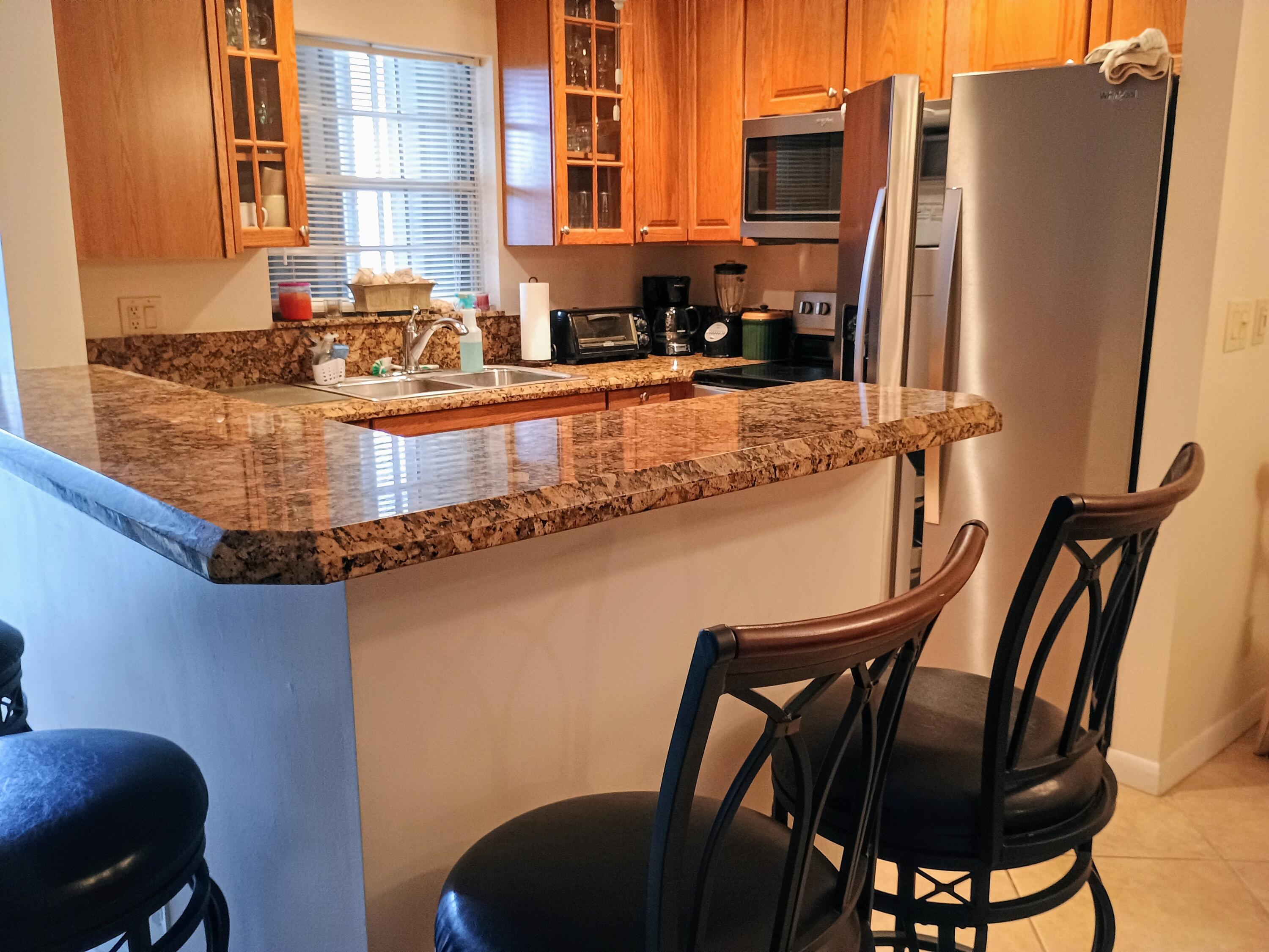 14716 Canalview Drive, Unit D Delray Beach, FL 33484 - Photo 3 of 17 a view of a chair and table in the kitchen