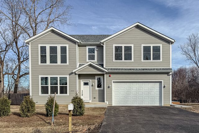 a front view of a house with yard and parking